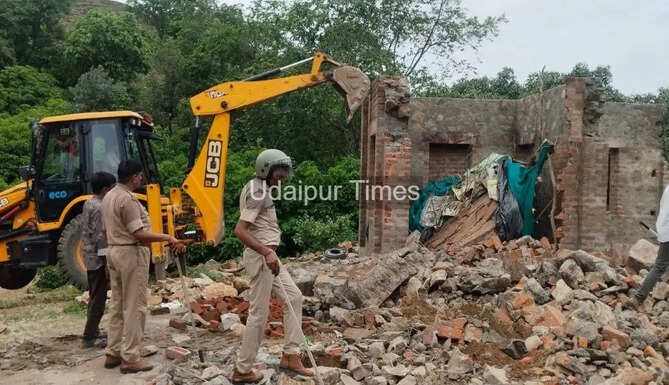 JCB machines demolish illegal construction on forest land during a joint operation by Udaipur Police, Forest Department, and district administration against history-sheeter Singaram Garasia in Bekaria, Udaipur.