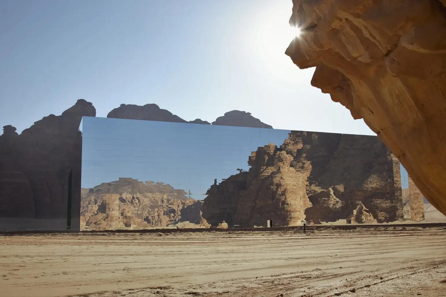 Hot air balloons flying over Hegra during AlUla Skies Festival with dramatic desert landscape and clear dark sky in Saudi Arabia.
