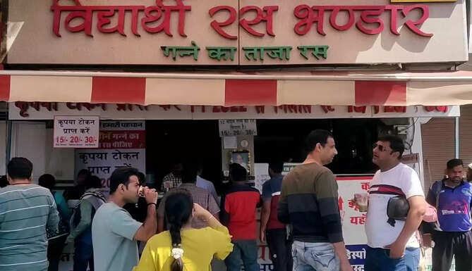गर्मी के मोसम में  विद्यार्थी रस भण्डार के यहाँ गन्ने का शुद्ध व ताज़ा रस पीने के लिए लंबी कतरों में खड़े लोग   