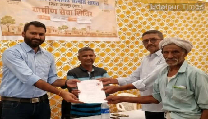 Officials assisting beneficiaries during Rural Service Camps in Udaipur where elderly citizens received social security pension approvals and Rajasthan Roadways free travel benefits.